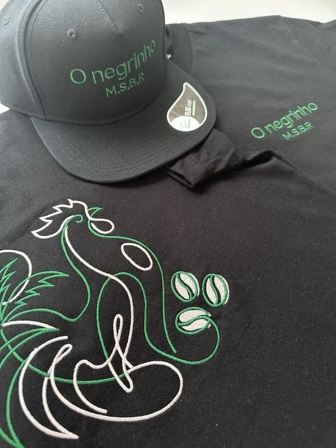 Boné e t-shirt pretos com bordado verde e branco de pormenor, feitos pela Embroidery Madeira